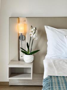 a white vase with flowers on a bedside table at Hotel Eden Palace au Lac in Montreux