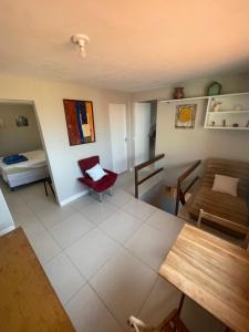 a living room with a red chair and a couch at Enjoy Hostel e Pousada in Aracaju