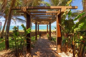 a wooden walkway in the middle of a beach at Casa Incrível em Barra do Cunhaú por Carpediem in Canguaretama
