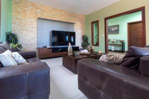 ein Wohnzimmer mit 2 Sofas und einem Flachbild-TV in der Unterkunft Casa Incrível em Barra do Cunhaú por Carpediem in Canguaretama