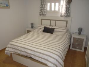 a bedroom with a bed with a black pillow on it at Modern Apartment Near Beach in La Mata