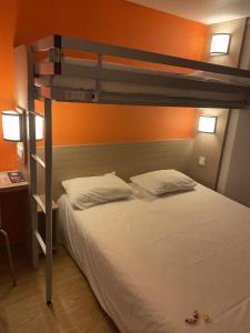 a bedroom with a bunk bed with white sheets and pillows at Premiere Classe Angoulême La Couronne in La Couronne