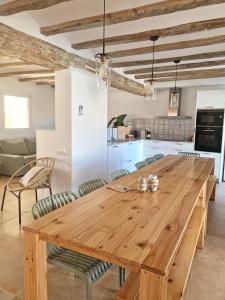 a large wooden table in a kitchen with chairs at Villa Barracot in Deltebre