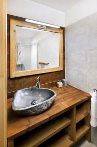 W łazience znajduje się kamienna umywalka i lustro. w obiekcie Apartman - Chalet Demänovka w Demianowskiej Dolinie