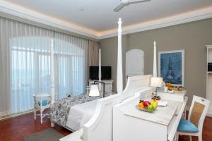 a bedroom with a bed and a table with a bowl of fruit at Villa Cavi in Puducherry