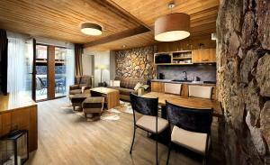 a kitchen and living room with a stone wall at Apartman - Chalet Demänovka Jasna in Belá