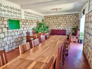 a room with tables and chairs and a stone wall at PermaKite in Andovokonko