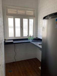 a kitchen with a counter and a refrigerator at Loft no Hotel Quitandinha in Petrópolis