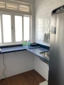 a kitchen with a counter and a sink and windows at Loft no Hotel Quitandinha in Petrópolis