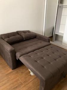 un canapé marron assis dans un salon dans l'établissement Loft no Hotel Quitandinha, à Petrópolis