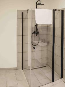 y baño con ducha y puerta de cristal. en Penzion Kamence, en Liptovský Mikuláš