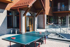 una mesa de ping pong frente a un edificio en Penzion Kamence, en Liptovský Mikuláš