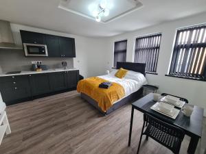 1 dormitorio con cama, mesa y cocina en Homestay by BIC Legends 3, en Batley Carr