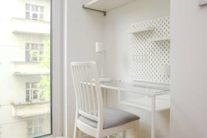a white desk and a chair next to a window at Luxury apartment in city center in Bratislava +1 photo