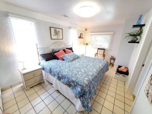 Un dormitorio con una cama con un edredón azul. en Large beautiful Magnolia in the sunny Saint Pete., en San Petersburgo