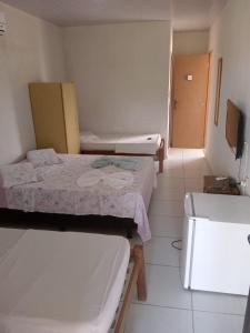 a small room with two beds and a bathroom at Pousada Sitio Paraíso in Cabo de Santo Agostinho