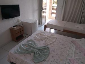 a bedroom with a bed with a blanket on it at Pousada Sitio Paraíso in Cabo de Santo Agostinho