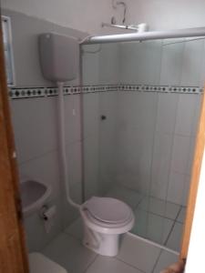 a white bathroom with a toilet and a shower at Pousada Sitio Paraíso in Cabo de Santo Agostinho