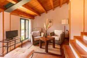 - un salon avec un canapé et une télévision dans l'établissement Hospedería el arco, à Villavieja del Lozoya