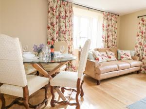 Bluebell Cottage في ريجلي: غرفة معيشة مع طاولة وأريكة