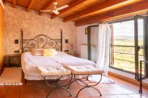 a bedroom with a bed and a large window at Hospedería el arco in Villavieja del Lozoya