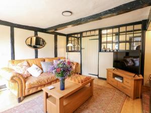 ein Wohnzimmer mit einem Sofa und einem Couchtisch in der Unterkunft Bluebell Cottage in Rugeley