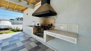 an outdoor kitchen with a stove and a hood at Departamento Coquimbo La Serena in Coquimbo