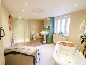 a bathroom with a tub and a shower and a sink at Bluebell Cottage in Rugeley +39 photos