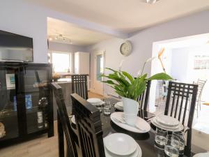 a dining room with a table with chairs and a clock at Thornberry in Salcombe