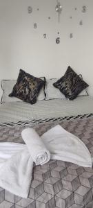 ein Bett mit weißen Handtüchern und Kissen darauf in der Unterkunft Los Ocobos Libano Tolima - Suite, Hostal y Restaurante in Líbano