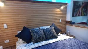 Schlafzimmer mit einem Kopfteil aus Holz und einem Bett mit Kissen in der Unterkunft Los Ocobos Libano Tolima - Suite, Hostal y Restaurante in Líbano
