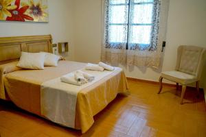 une chambre avec un lit, une chaise et une fenêtre dans l'établissement La Masía casa rural junto al río, à Almedinilla 32 autres photos