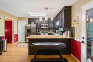 a kitchen with wooden cabinets and a bar with a stool at Townhouse in Marietta in Marietta