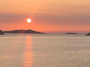 einen Sonnenuntergang über dem Wasser mit Bergen im Hintergrund in der Unterkunft Villa Iva Lastovo in Ubli