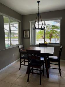 a dining room with a table and chairs and a chandelier at Its A Dream Family Vacation Rental - Minutes from Disney in Kissimmee