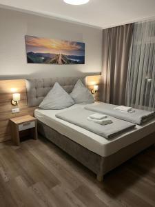 1 dormitorio con 1 cama grande con sábanas blancas en Hotel Seewiefken, en Wangerland