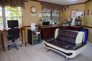 a salon with a leather chair and a desk with a computer at Flamingo Motel in Okeechobee