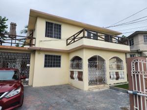 a house with two dogs in cages in front of it at 11onEssex1 in the heart of Kingston Ja DN Vacations in Kingston