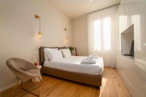 een slaapkamer met een bed, een stoel en een televisie bij Residenza del Principe - DB Apartment in Florence