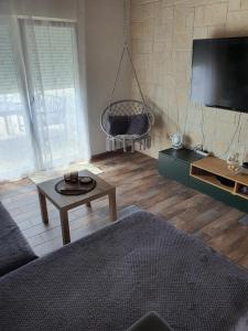 a living room with a couch and a tv at Kuća za odmor SeaHouse in Karlobag