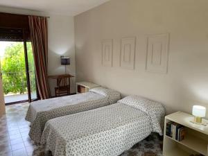 two beds in a hotel room with a window at Casa vacanza in Cassino