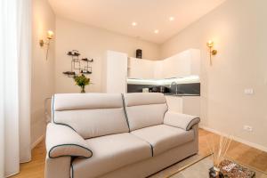 een witte bank in een woonkamer met een keuken bij Residenza del Principe - DB Apartment in Florence