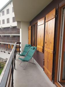 two green chairs on the balcony of a building at Casa a Rucas in Montoso