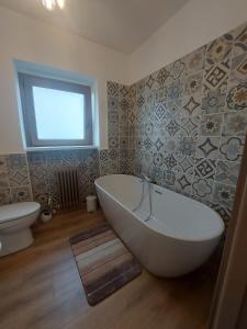 a bathroom with a tub and a toilet and a window at Casa a Rucas in Montoso