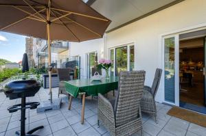 a patio with a table and chairs and a grill at FeWo Prora - Dünenterrasse in Binz