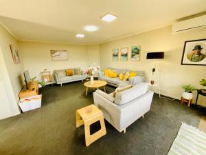 a living room with couches and a table at Free-Range On Papmoa Beach in Tauranga