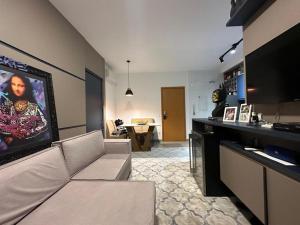 a living room with a couch and a flat screen tv at Flat vista mar em Santos in Santos