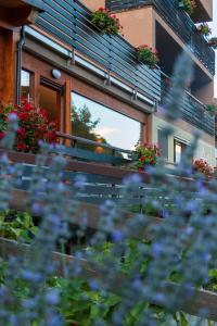 um banco em frente a um edifício com flores em Hotel La Val em Valdidentro