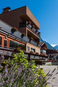 un edificio con piante in vaso sul lato di Hotel La Val a Valdidentro