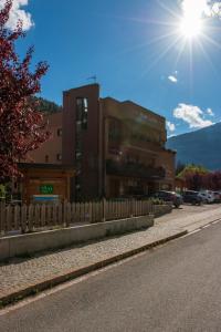 a building with a fence on the side of a street at Hotel La Val in Valdidentro